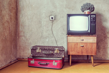 old room. retro tv and two suitcases