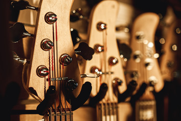 Uppermost part of the guitar. Close view of several acoustic guitar headstocks with tuning keys for...