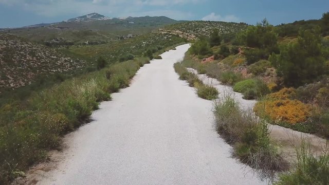 Forward drone shot over a motorcyclist passing under the camera during a summer afternoon. 4k drone quality