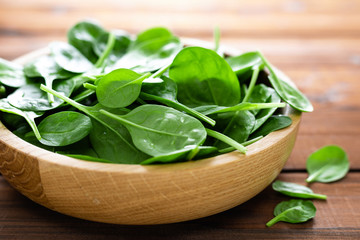Fresh spinach leaves on wooden background. Healthy vegan food