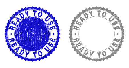Grunge READY TO USE stamp seals isolated on a white background. Rosette seals with grunge texture in blue and gray colors. Vector rubber stamp imitation of READY TO USE text inside round rosette.