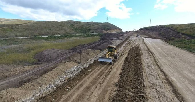 Road construction with grader in Kazakhstan desert in autumn daytime