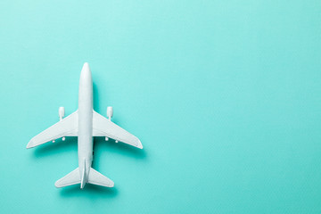 White passenger plane on green mint background. Copy space for text.