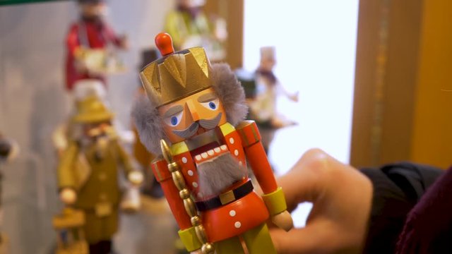 Slow Motion shot of a woman playing with a wooden Bavarian nutcracker toy.