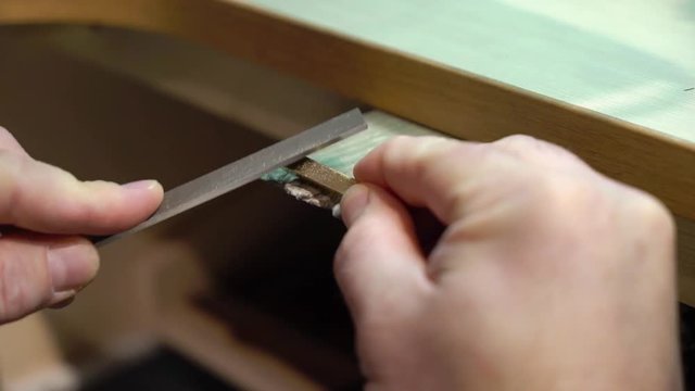 Jeweler makes a piece of jewelry - golden wedding ring