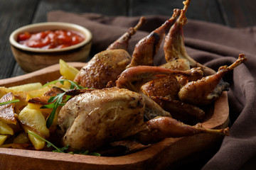 Grilled quails with fried potatoes and tomato dip.