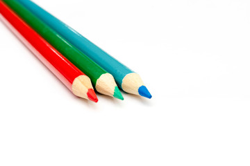 Three colored pencils. The colors red, green and blue. The concept of polygraphy and digital RGB color transfer.