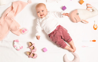 Cute little baby with clothing and accessories on white background, top view