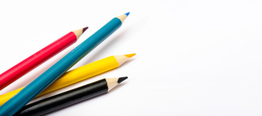 Four colored pencils. The colors cyan, magenta, yellow and black. The concept of polygraphy.