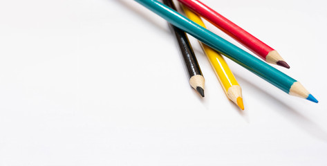 Four colored pencils. The colors cyan, magenta, yellow and black. The concept of polygraphy.