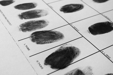 Police form with fingerprints, closeup. Forensic examination