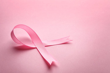Pink ribbon on color background, space for text. Breast cancer awareness concept