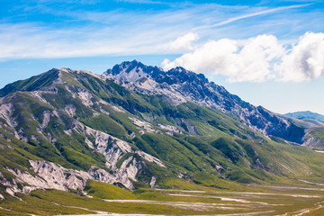 Fototapeta premium green valley in summer, among the rocky mountains , spectacular nature, panorama in a cloudy day
