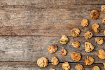 Flat lay composition with figs on wooden background, space for text. Dried fruit as healthy food