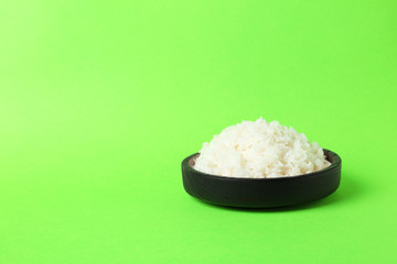 Bowl of boiled rice on color background. Space for text
