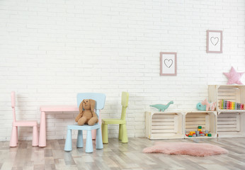 Cozy kids room interior with table, chairs and toys