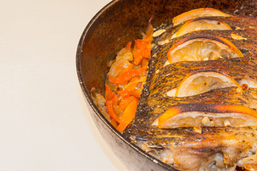 Baked silver carp. Preparing  carp in the oven. Silver carp with side dish at the pan. Fish cook at home.
