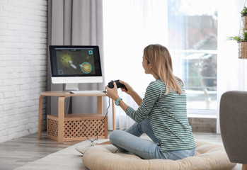 Young woman playing video game at home