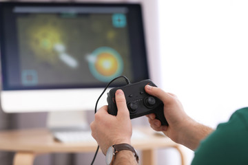 Young man playing video game at home, closeup