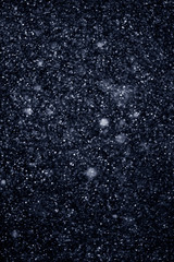 Artificial snow falling on a black background as overlay