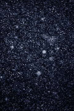 Artificial snow falling on a black background as overlay