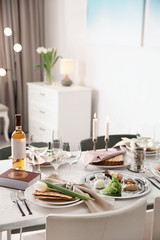 Festive Passover table setting with Torah at home. Pesach celebration
