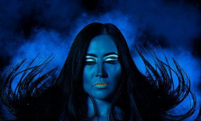 Fototapeta premium High fashion model woman. Art mystical blue, gold skin girl face portrait