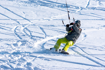Fototapeta na wymiar Snowboarder on a snowboard with snow kite on the fresh snow. Concept of outdoor extreme activities in winter snowkite