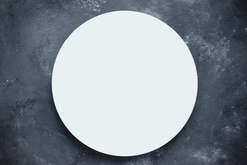 Empty white round plate on dark background