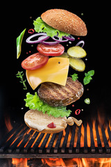 Hamburger ingredients falling down one by one to create a perfect meal. Colorful conceptual picture of burger cooking.