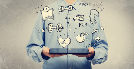 Fitness and diet with young man holding a tablet computer