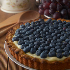 Blueberry Tart or cake with cream and berries. Fresh sweet dessert with fruits. homemade food, wooden, rustic background.
