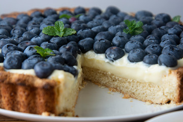 Blueberry Tart or cake with cream and berries. Fresh sweet dessert with fruits. homemade food, wooden, rustic background.