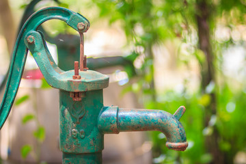Old manual water pump (Lever pump). Vintage cast iron water pump with handle for pumping.