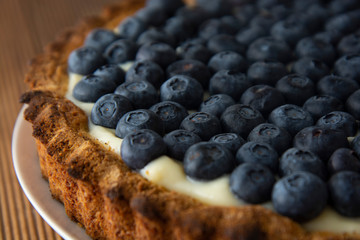 Close up blueberry tart or cake with cream and berries. Fresh sweet dessert with fruits. Homemade...