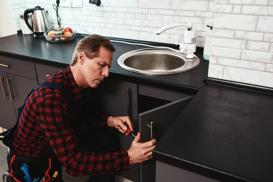 Fixing sink process. Seniour handyman repairing washbasin