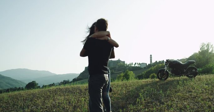 Young couple spending romantic time together in amazing landscape , beside their motorcycle. 4k