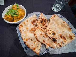 Close up shot of a dish with bread and Indian style curry