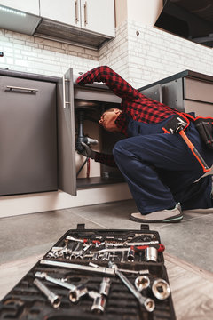 All tools just in case. Seniour handyman repairing washbasin at the kitchen