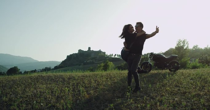 Couple spending time together hugging each other in the middle of amazing landscape they travel together