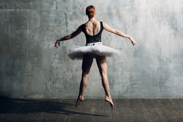 Fototapeta na wymiar Ballerina female. Young beautiful woman ballet dancer, dressed in professional outfit, pointe shoes, black top and white tutu.