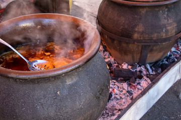 Preparing food outdoor for many people, direct on fire in a big pot.