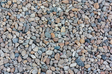 Natural colorful pebble (stones) background texture with copy space.