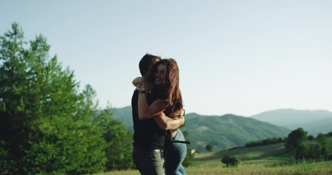 Summer vibes for a young couple in the middle of nature spending romantic time together traveling with their motorcycle.