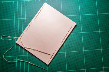 Needle and thread on leather.