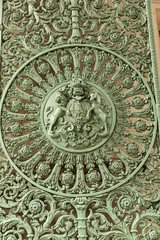 Puerta verde de hierro fundido con decoraciones.