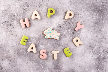 Happy Easter colorful lettering Happy Easter of ginger biscuits and cookies bunny on stone background.