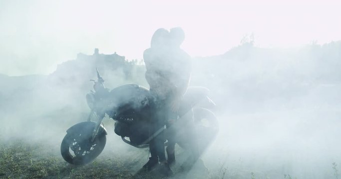 In a blurred imagines couple charismatic beside of their motorcycle speeding a romantic time together , in the middle of nature.