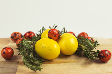 Easter. Easter eggs on a wooden stand with sprigs of rosemary on a white background.