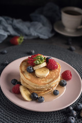 Delicious american pancakes with berries, banana and syrup. Vertical. Copyspace